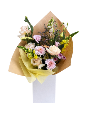 Bouquet of flowers wrapped in brown paper with a white box underneath on a white background for delivery in Vancouver BC
