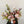 Designers choice flower arrangement with vase with seasonal greenery and pastel roses.