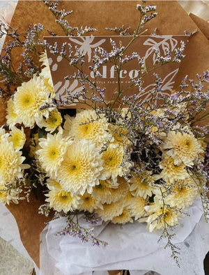 Pastel spray mum bouquet wrapped in kraft paper